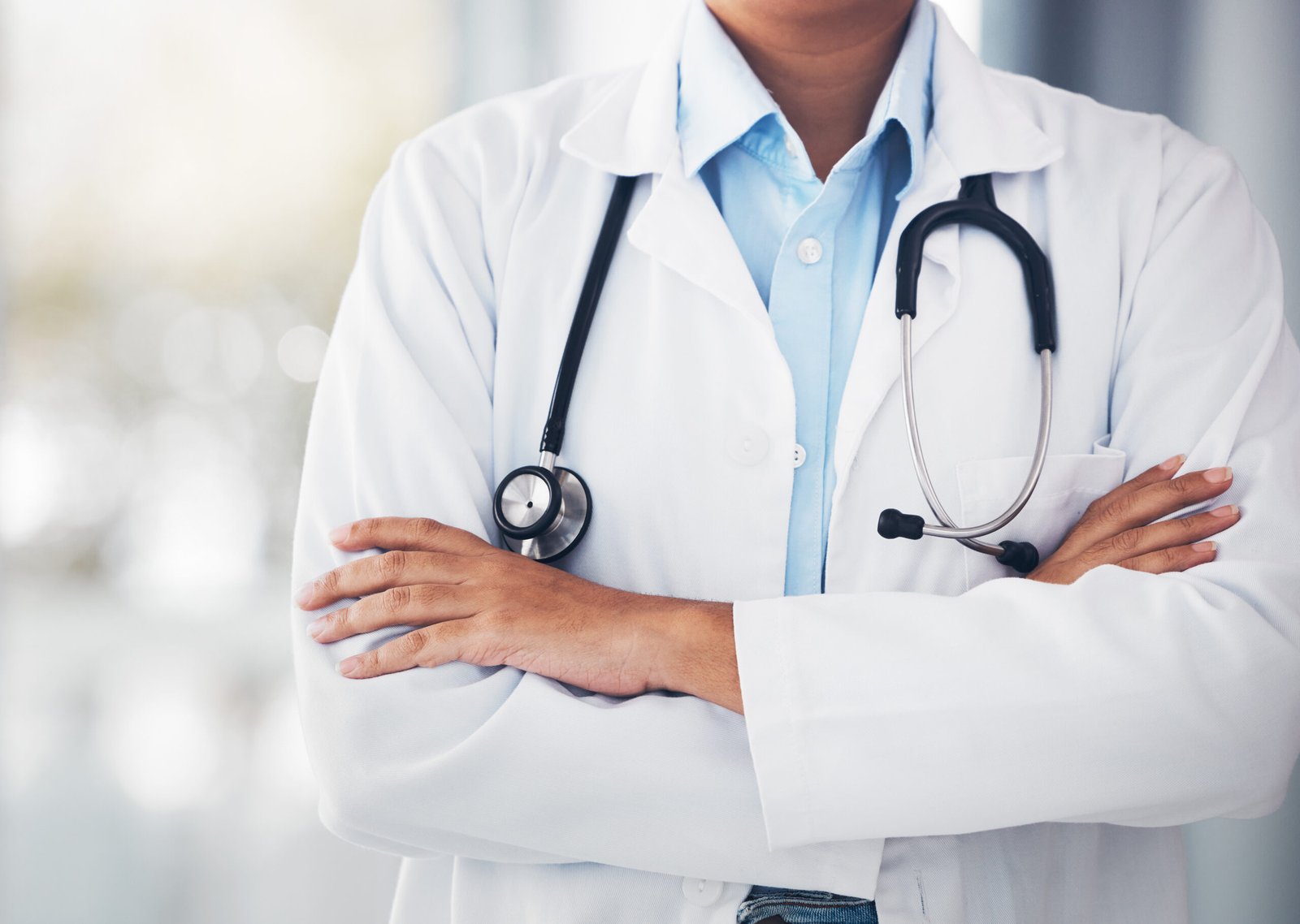 Person, hands and professional doctor with arms crossed or stethoscope for cardiology or healthcare.